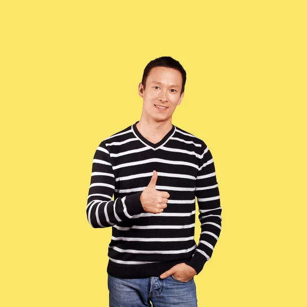 亚洲男子在条纹套衫显示拇指在时髦的梯度背景 — 图库照片