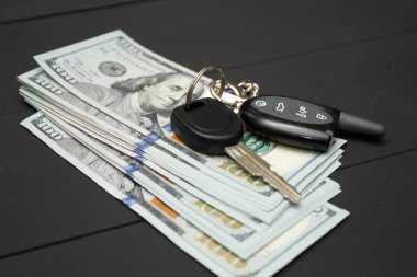 Siyah arka plan üzerine dolar para nakit. Para ve araba anahtarı yığını