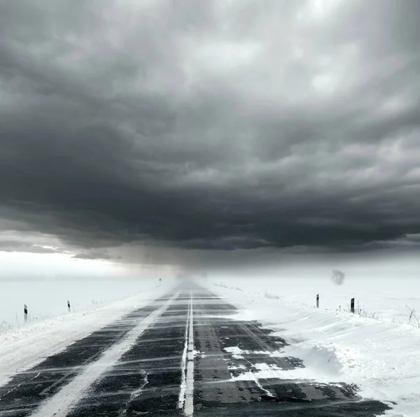 Céu tempestuoso e estrada de neve — Fotografia de Stock