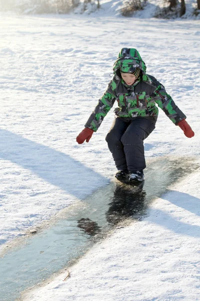 Junge rutscht auf Eisbahn — Stockfoto