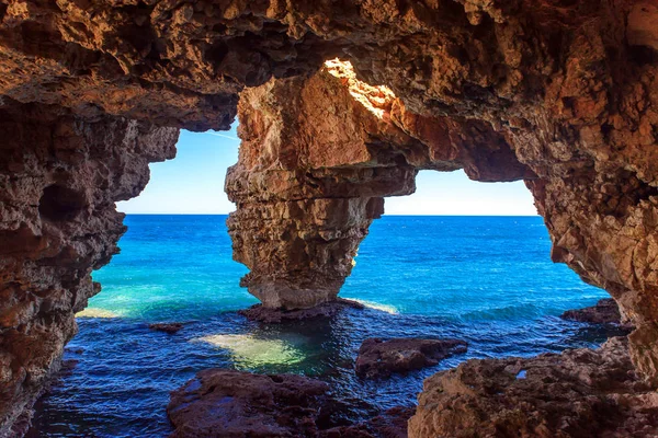 Grotta naturale sulla costa in Spagna, Moraira, Alicante, Cova dels Arcs Fotografia Stock