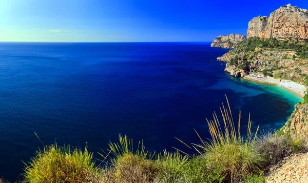 Moraira 'da mavi denizi, plajı ve dağları olan güzel bir manzara.