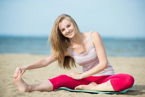 Jonge dame praktizerende yoga. Training in de buurt van de kust van de zee oceaan. — Stockfoto