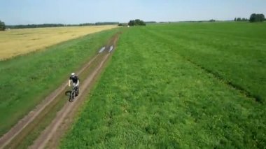 Anteni: yeşil ve sarı alan ile kırsal Road bisiklet üzerinde Bisiklete binme genç adam.