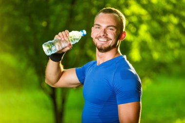 atletik olgun adam içme suyu bir şişe