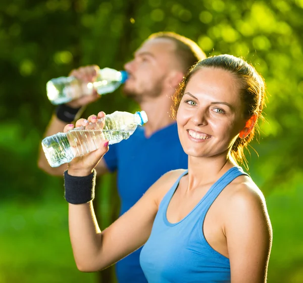 Homem e mulher bebendo água da garrafa após o exercício de fitness sport — Fotografia de Stock