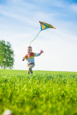 Genç çocuk onun uçurtma yeşil alan ile oynarken.