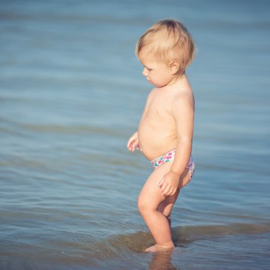 Şirin Bebek kumlu plajı ve deniz suyu oynarken.