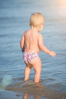 Şirin Bebek kumlu plajı ve deniz suyu oynarken.