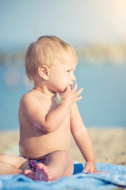 Şirin Bebek denize yakın kum plajındaki oyuncaklar ile oynama.