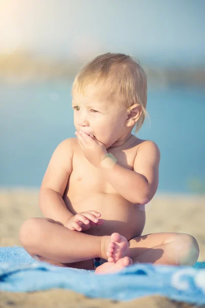 Lindo bebé jugando con juguetes en la playa de arena cerca del mar . —  Fotos de Stock