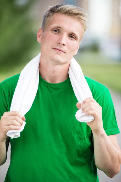 Trött man efter fitness tid och träning. Med vit handduk — Stockfoto