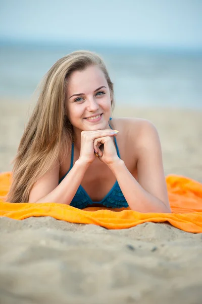 Νεαρή κοπέλα ηλιοθεραπεία σε μια παραλία. Όμορφη γυναίκα που παρουσιάζουν κατά την — Φωτογραφία Αρχείου