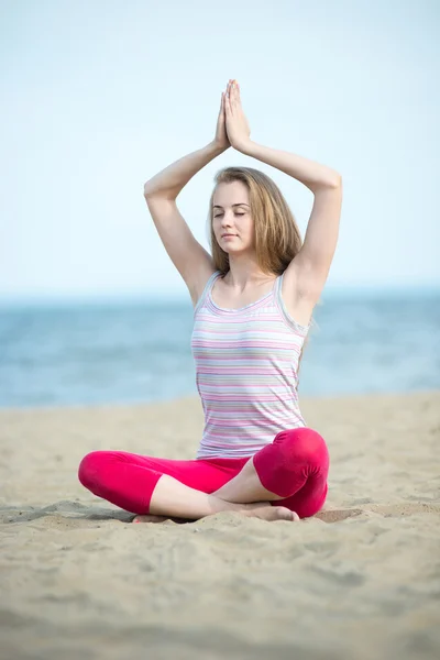 Young lady practicing yoga. Workout near ocean sea coast. — Stock Photo, Image