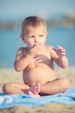 Şirin Bebek denize yakın kum plajındaki oyuncaklar ile oynama.