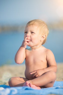 Şirin Bebek denize yakın kum plajındaki oyuncaklar ile oynama.