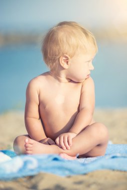 Şirin Bebek denize yakın kum plajındaki oyuncaklar ile oynama.