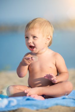 Şirin Bebek denize yakın kum plajındaki oyuncaklar ile oynama.