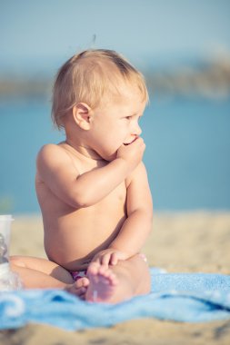 Şirin Bebek denize yakın kum plajındaki oyuncaklar ile oynama.