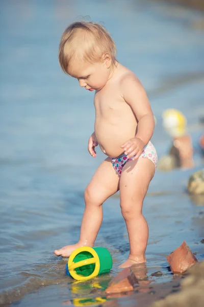 Słodkie dziecko grając na piaszczystej plaży i w wodzie morskiej. — Zdjęcie stockowe