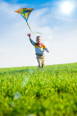 Genç çocuk onun uçurtma yeşil alan ile oynarken.