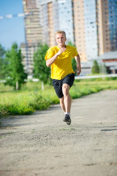 Un uomo sportivo che fa jogging nel parco cittadino. Fitness all'aperto . — Foto Stock