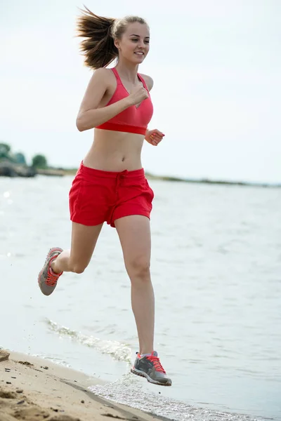 Young lady running at the sunny summer sand beach. Workout.  Jog — Stock Photo, Image