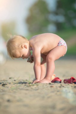 Şirin Bebek denize yakın kum plajındaki oyuncaklar ile oynama.