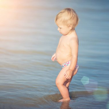 Şirin Bebek kumlu plajı ve deniz suyu oynarken.