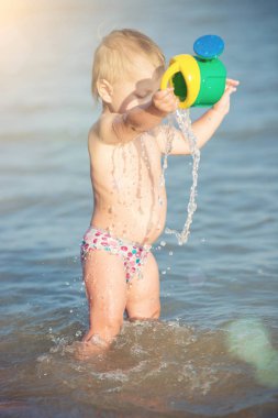 Şirin Bebek kumlu plajı ve deniz suyu oynarken.