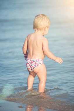 Şirin Bebek kumlu plajı ve deniz suyu oynarken.