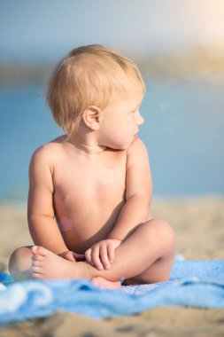 Şirin Bebek denize yakın kum plajındaki oyuncaklar ile oynama.