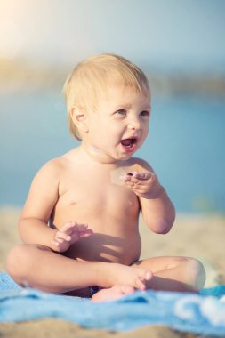 Şirin Bebek denize yakın kum plajındaki oyuncaklar ile oynama.