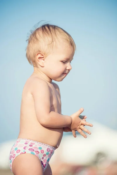 Carino bambino che gioca con i giocattoli sulla spiaggia di sabbia vicino al mare . — Foto Stock