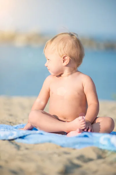 Lindo bebé jugando con juguetes en la playa de arena cerca del mar . —  Fotos de Stock