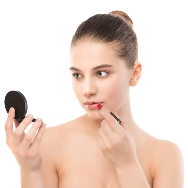 Young brunette woman with perfect clean face applying lipstick using mirror. Isolated on a white. — Stock Photo, Image