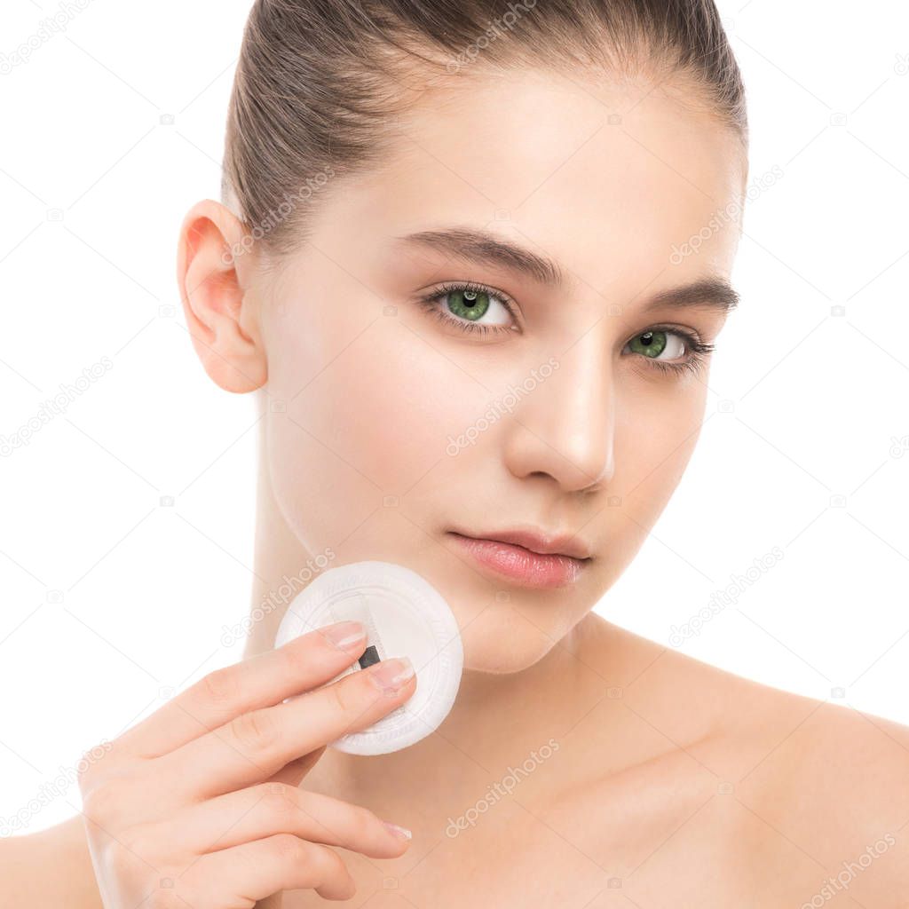 Young woman cares for face skin. Cleaning perfect fresh skin using cotton pad. Isolated.