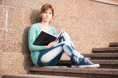 Merdivenlerde oturan ve Not okuma kız
