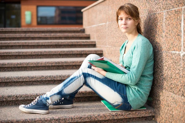 Дівчина сидить на сходах і читає записку — стокове фото