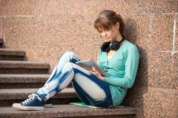 Beautiful young woman student with note pad and headphones. Outdoor student. — Stock Photo, Image
