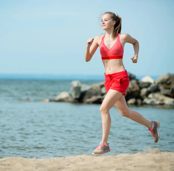 Юная леди бежит на солнечном летнем песчаном пляже. Тренировка. Бег — стоковое фото