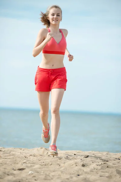 Νεαρή κοπέλα που τρέχει στην παραλία άμμου ηλιόλουστο καλοκαίρι. Προπόνηση. Σπρώχνω — Φωτογραφία Αρχείου