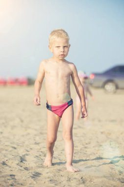 Kumsal deniz kenarında yürürken erkek sevimli bebek. Okyanus kıyısı.