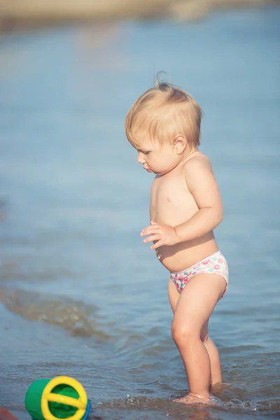 Симпатичный ребенок, играющий на песчаном пляже и в морской воде . — стоковое фото