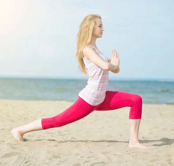 Ung dam praktisera yoga. Träning nära havet seglar utmed kusten. — Stockfoto