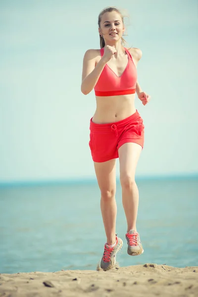 Ung dam kör på solig sommar sand stranden. Träning. JOG — Stockfoto