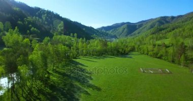 UHD 4k havadan görünümü. Düşük uçuş taze soğuk dağ nehir, çayır ve yola güneşli yaz sabahı.