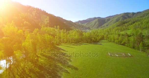 UHD 4K вид сверху. Низкий полет над свежей холодной горной рекой, лугом и дорогой в солнечное летнее утро . — стоковое видео