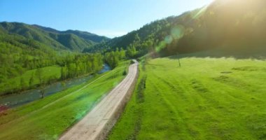 Havadan Uhd 4k görünümü. Düşük hava uçuş dağ kırsal toprak yol ve çayır üzerinde.