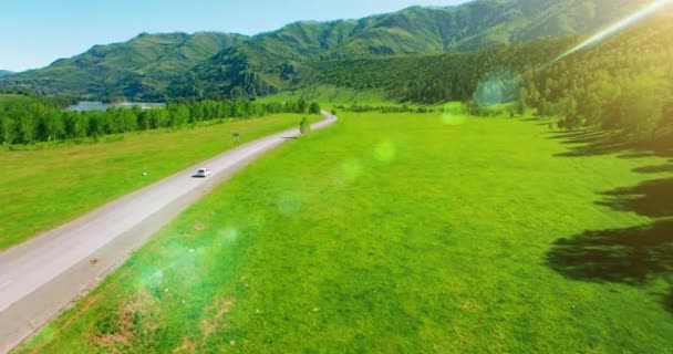 Survol de voitures sur une route sinueuse dans les collines et le pré. Autoroute rurale en dessous . — Video